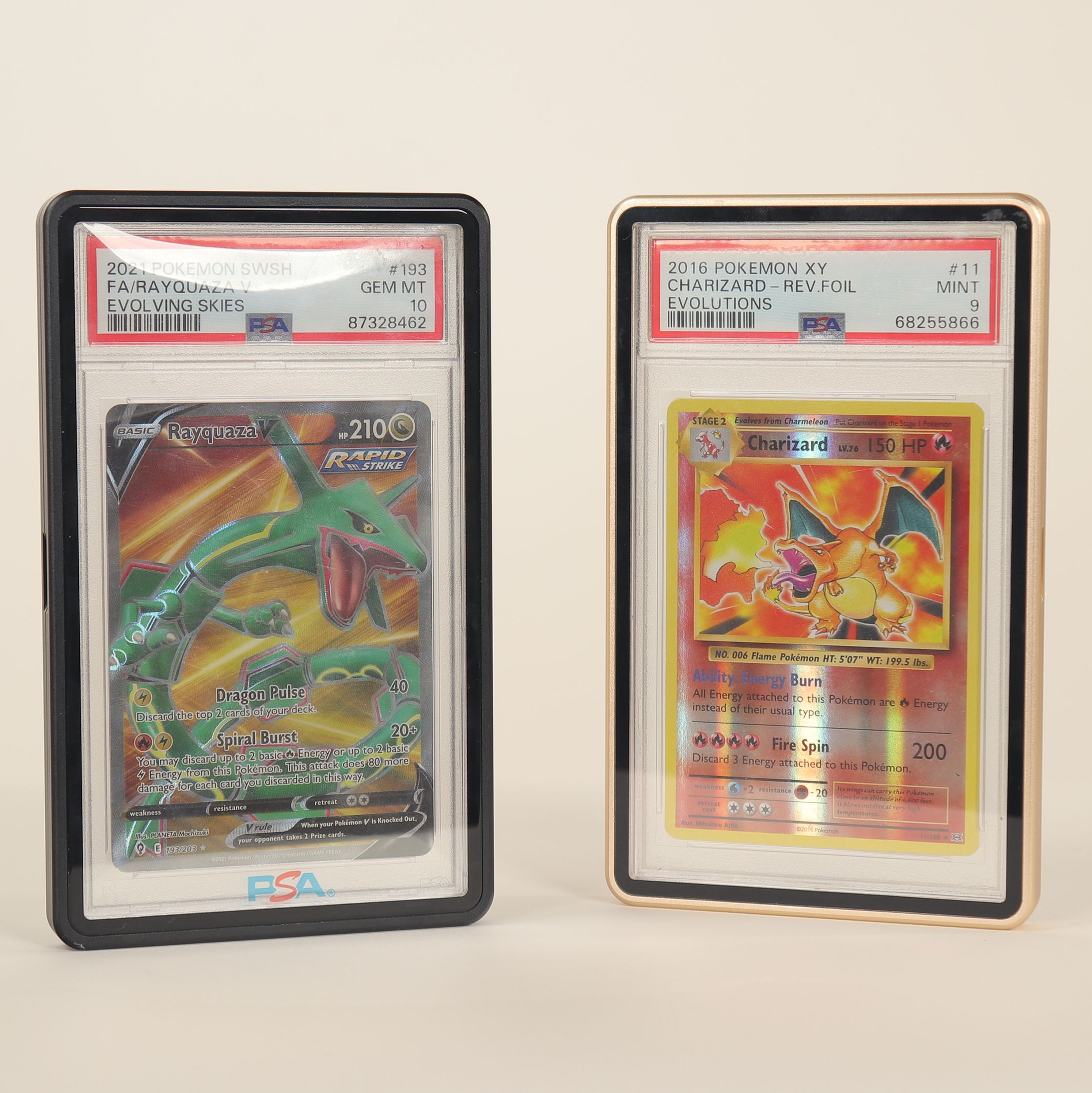 Two metal cases for Pokémon trading cards with PSA grading labels on a white background