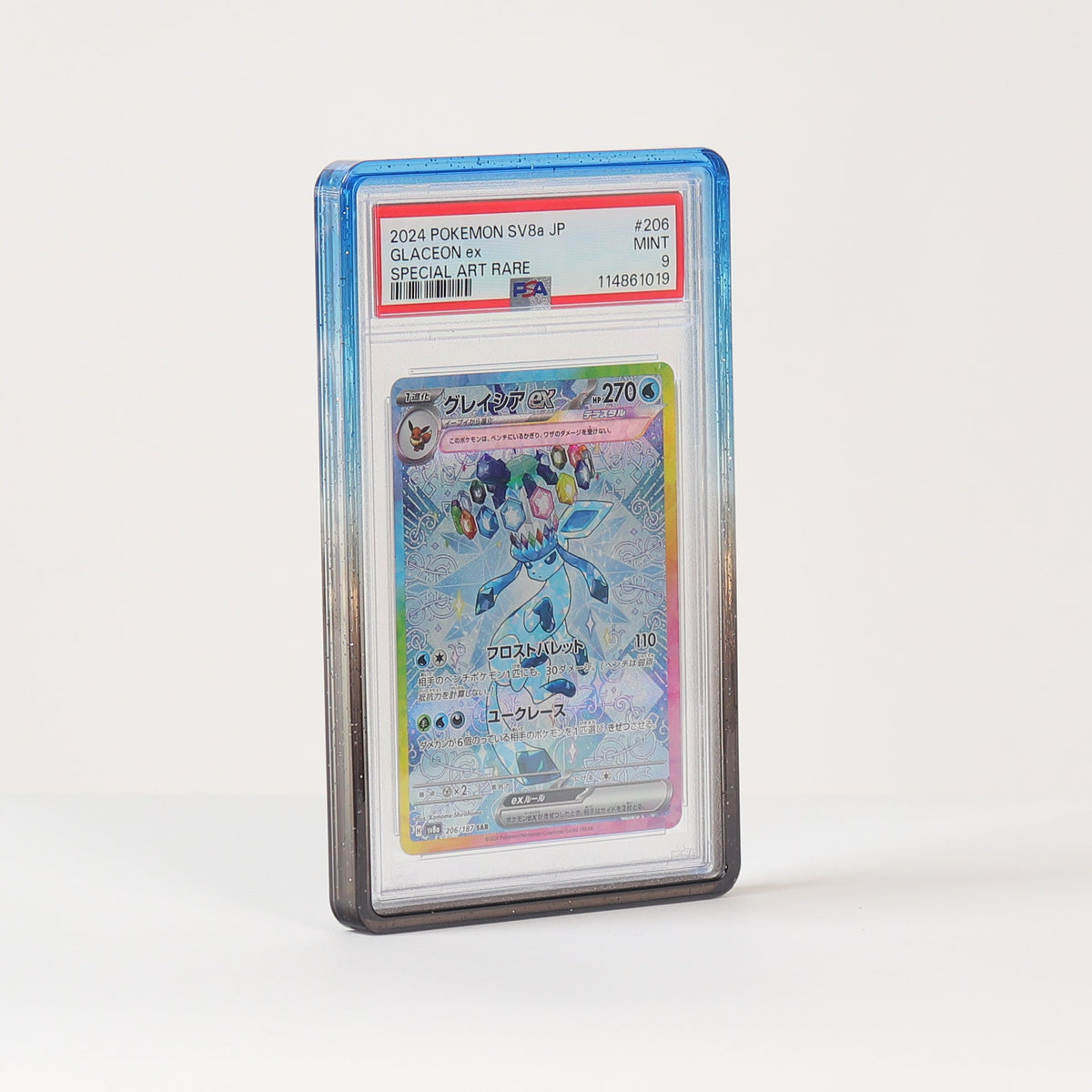 A graded holographic Pokémon card in a clear PSA-style slab, standing upright on a white surface against a white background.