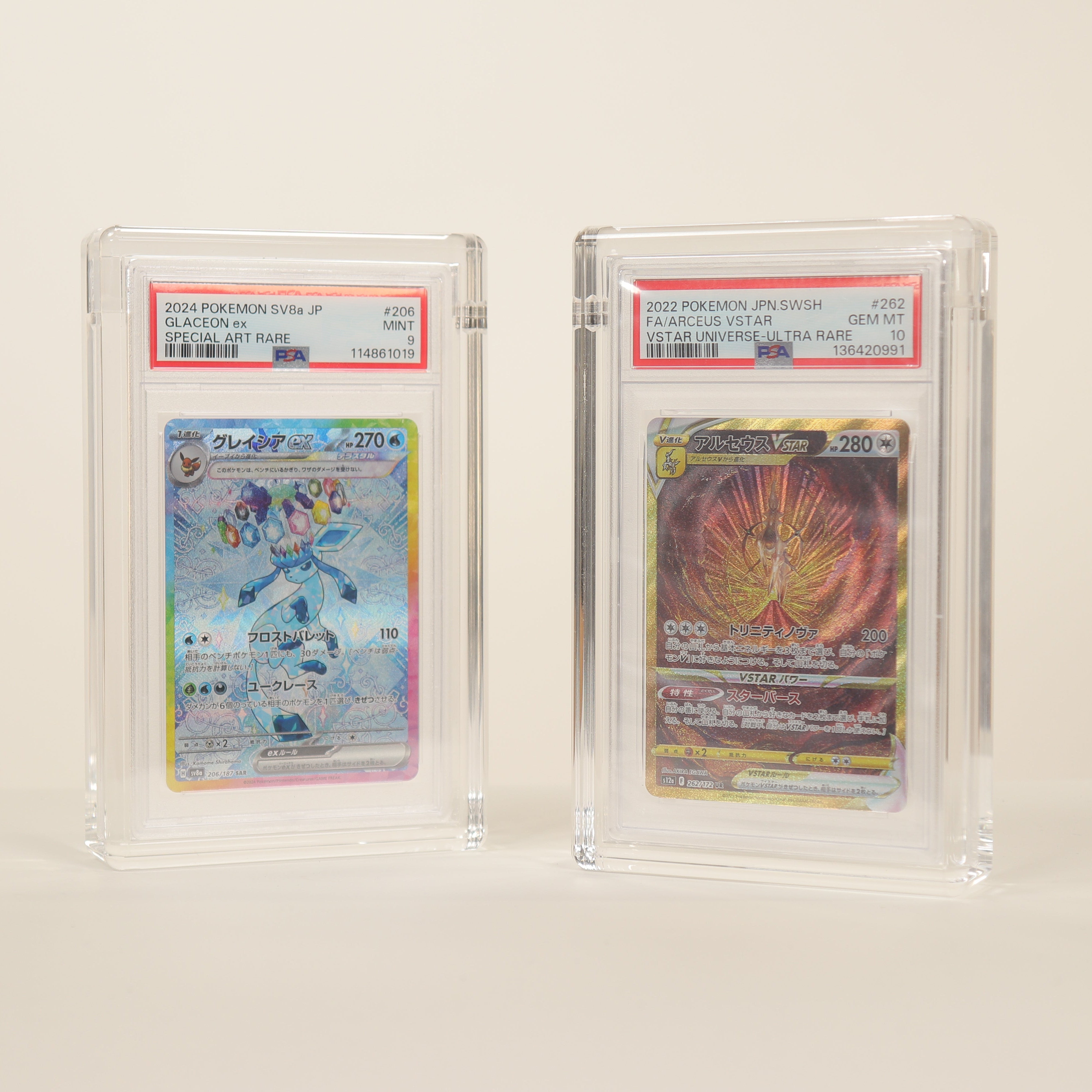 Two trading cards in protective cases on a white background